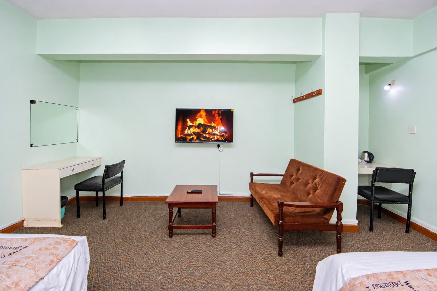 Sofa, desk and TV in a carpeted room